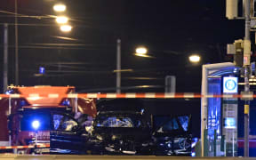 Forensics police inspect the car that rammed into a crowd at a Christmas market in Magdeburg, eastern Germany, on December 21, 2024. German police arrested a Saudi Arabian man after a deadly car-ramming attack on a Christmas market December 20, 2024 in which an SUV barrelled through a crowd of revellers at high speed, leaving a trail of bloody carnage. At least two people were killed, one of them a young child, and 68 injured, said authorities in the city of Magdeburg, located about 130 kilometres (80 miles) southwest of Berlin. Families were crowded at the market set up around a large Christmas tree in the centre of Magdeburg when a BMW barrelled towards them around 7 pm (1800 GMT). (Photo by John MACDOUGALL / AFP)