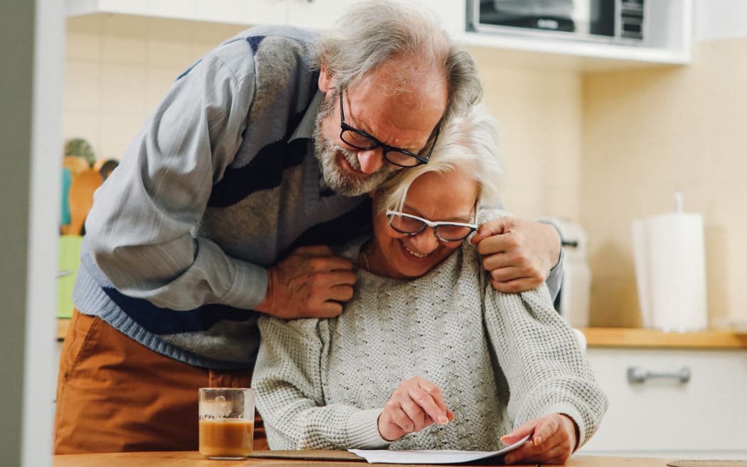 An elderly couple hug