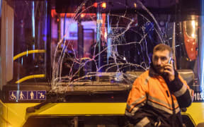 A Turkish emergency worker stand in front of a damaged bus on the site where a car bomb exploded near the stadium of football club Besiktas in central Istanbul on December 10, 2016.