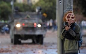 A demonstrator wearing a mask stands behind a column during clashes with riot police which erupted during the protest against the government of Colombian President Ivan Duque, in Suba neighbourhood, Bogota yesterday.