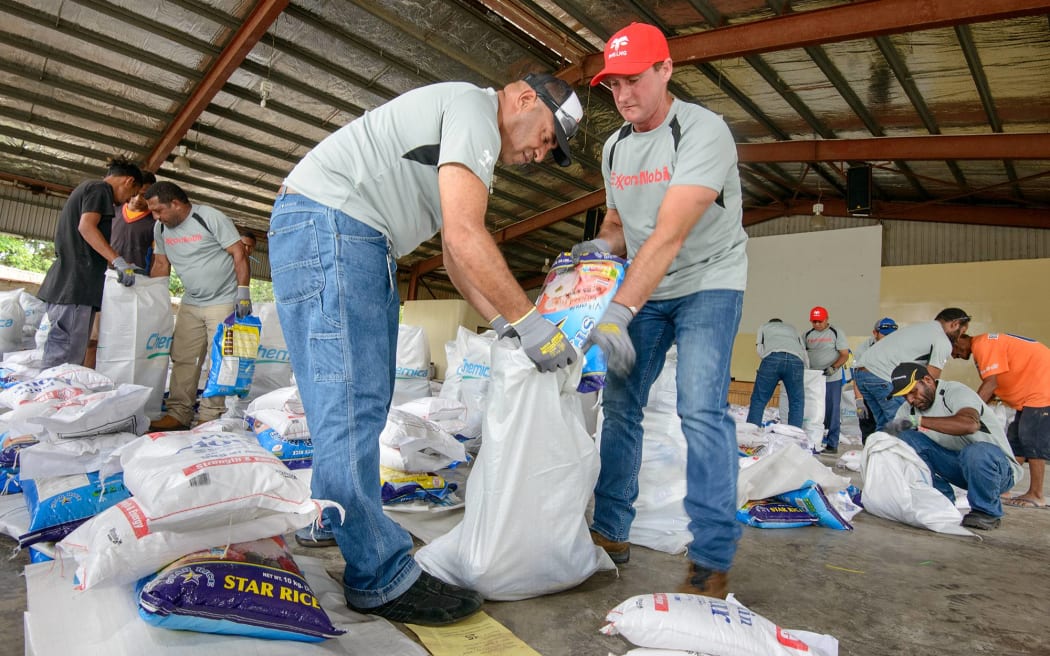 ExxonMobil PNG’s Managing Director Andrew Barry (centre right) and Community Affairs Coordinator Mohammed Paul (centre left) packing goods at the Salvation Army.
