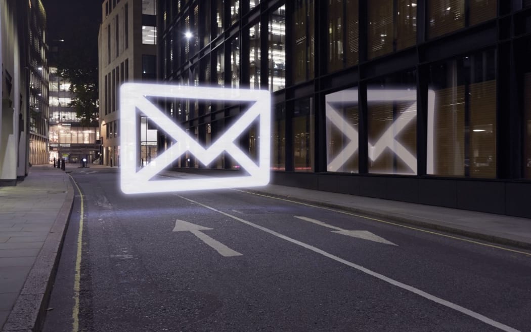 Glowing email icon in street at night, London UK