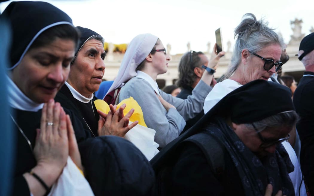 Nuns listen to newly elected Pope Robert Francis Prevost, Pope Leo XIV, address the crowd from the main central loggia balcony of the St Peter's Basilica for the first time, after the cardinals ended the conclave, in The Vatican, on May 8, 2025. Robert Francis Prevost was on May 8, 2025 elected the first pope from the United States, the Vatican announced. A moderate who was close to Pope Francis and spent years as a missionary in Peru, he becomes the Catholic Church's 267th pontiff, taking the papal name Leo XIV. (Photo by Dimitar DILKOFF / AFP)