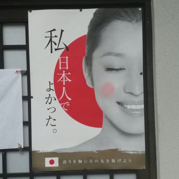 The poster, which has been put up in many places around Kyoto, says "I'm glad to be Japanese. Raise the Hinomaru (flag) with pride in your heart," - but the image used is of a Chinese model, and from a Beijing production company.