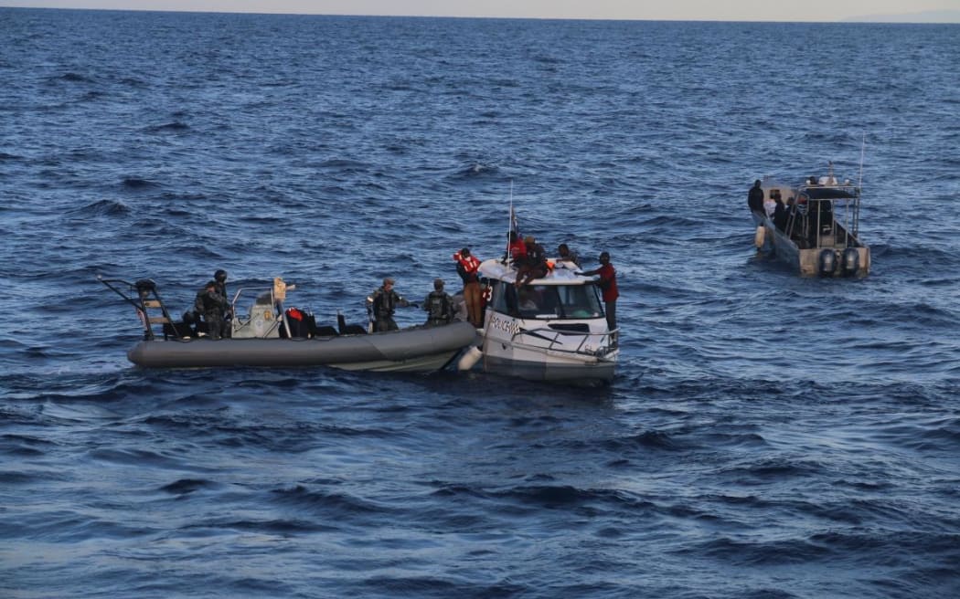 Royal Australian Navy personnel transfer passengers from a stricken Royal Solomon Islands Police Force vessel to HMAS Ararat