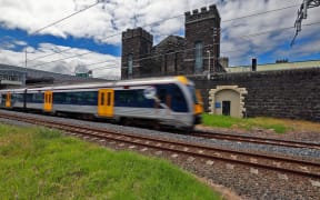 An Auckland Transport train passes by Mt Eden prison