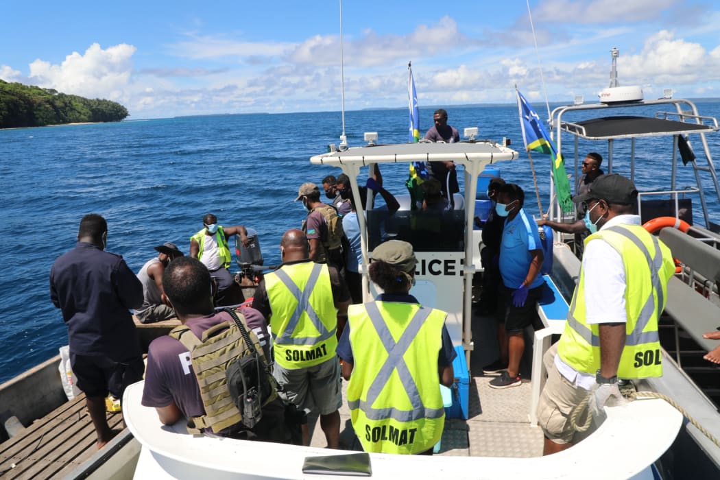Solomon Islands government officials (Wearing high visibility vests) handing over the two fishermen to their Bougainville counterparts.