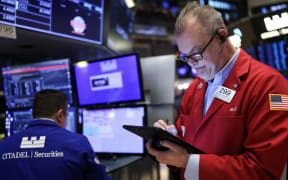 Traders work on the floor of the New York Stock Exchange (NYSE) at the opening bell in New York City, on April 3, 2025. Wall Street stocks sank in early trading on April 3,2025, joining a global equity selloff after President Donald Trump's latest tariff announcement exacerbated worries about a trade war and global economic downturn. (Photo by CHARLY TRIBALLEAU / AFP)