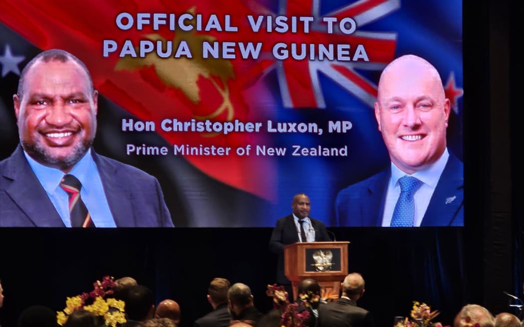 An image of Papua New Guinea's prime minister James Marape and New Zealand Prime Minister Christopher Luxon on a screen behind Marape as he makes a speech in Papua New Guinea to mark 50 years of diplomatic ties between the two countries.