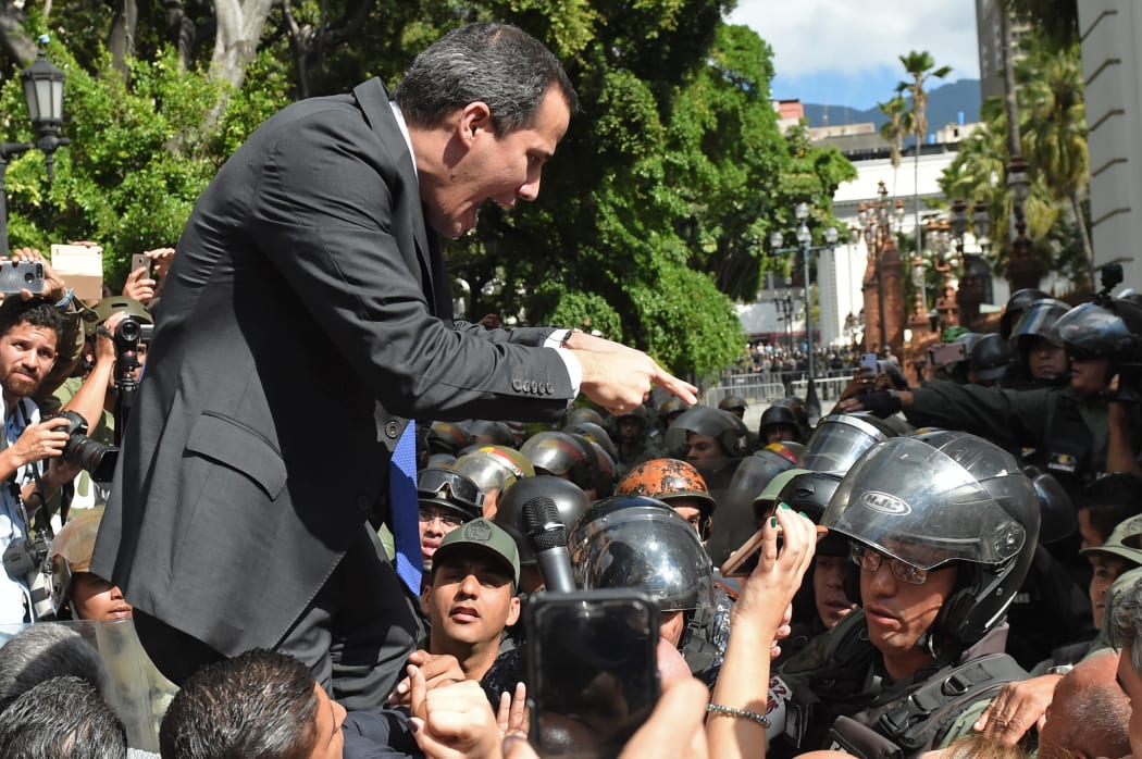 Venezuelan opposition leader and self-proclaimed acting president Juan Guaido confronts Bolivarian National Guard members.