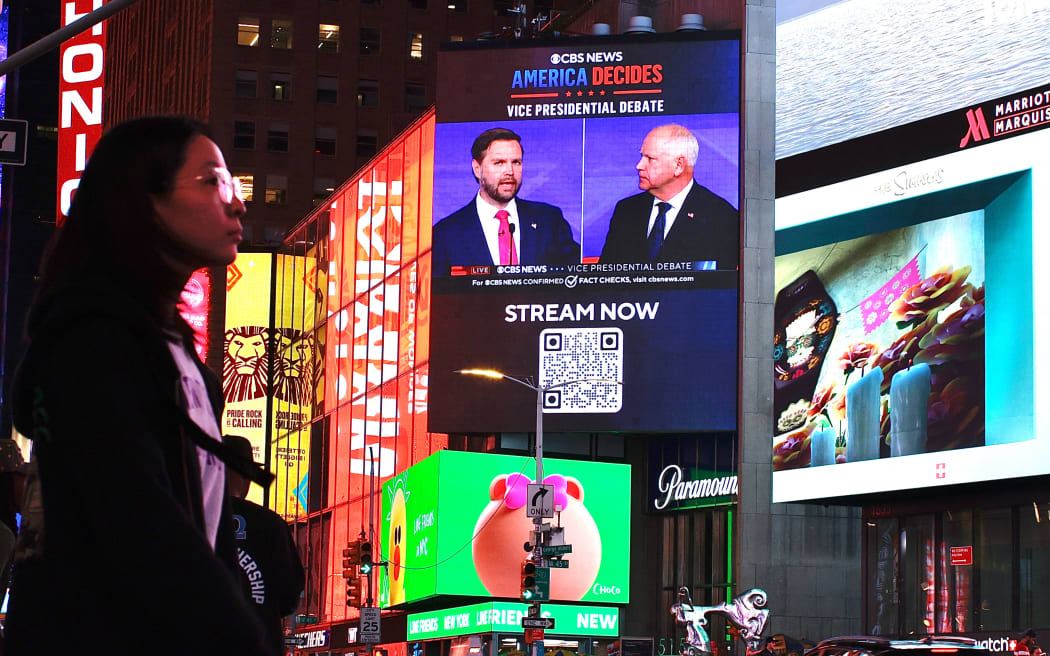 A screen displays the CBS vice presidential debate between US Senator and Republican vice presidential candidate J.D. Vance and Minnesota Governor and Democratic vice presidential candidate Tim Walz in Times Square in New York on October 1, 2024. (Photo by Kena Betancur / AFP)