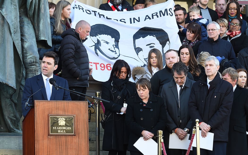 British Labour party MP for Leigh, Andy Burnham, stands at a podium and reads some of the names of the 96 victims of the 1989 Hillsborough disaster,