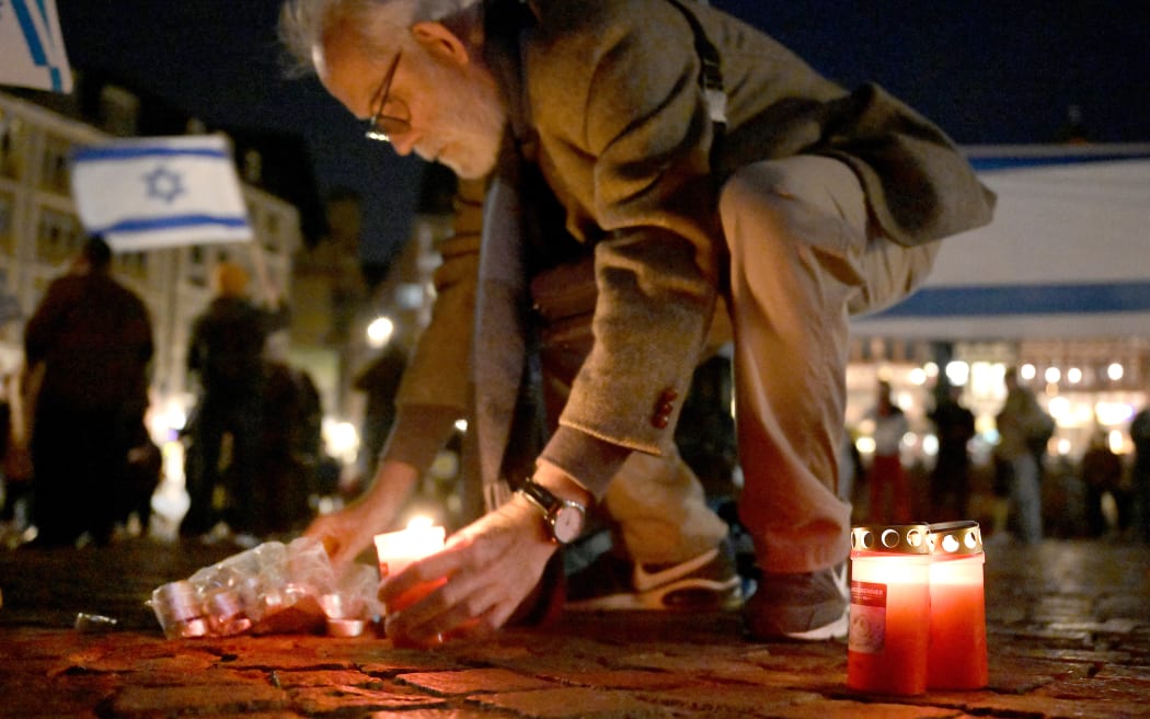 07 October 2023, Hesse, Frankfurt/Main: A man lights candles at the rally. Several hundred people take part in the rally. Photo: Hannes P. Albert/dpa (Photo by Hannes P Albert / DPA / dpa Picture-Alliance via AFP)
