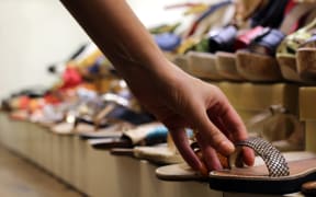 slipper shop woman hand choosing pair of shoes in shoe store