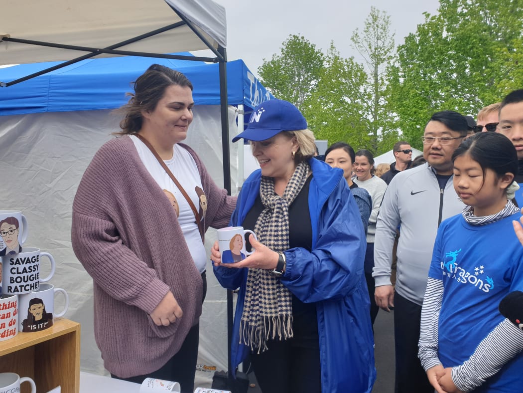 Judith Collins (centre) with Lisa Stirling (left) holding the mug with her face on it.