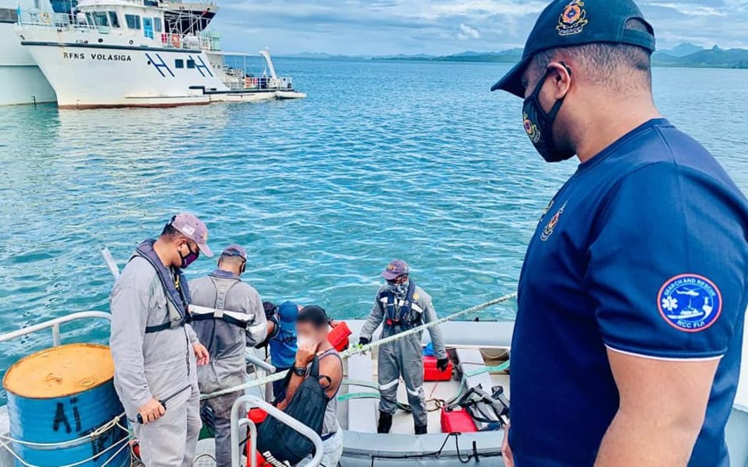 A Fijian Navy crew hand over the survivors found on board the FV TIRO II to Fiji police.