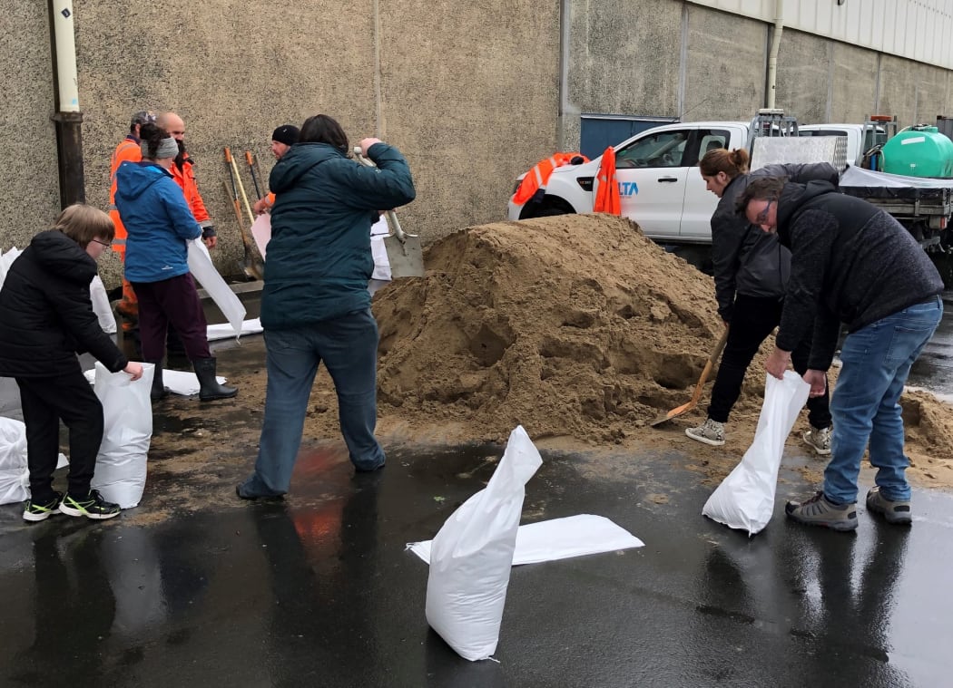 People fill bags at one of Dunedin's sandbagging stations