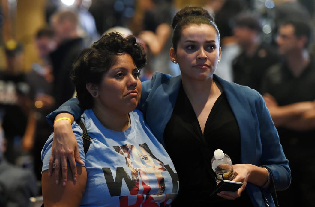 Hillary Clinton supporters Susan Taylor (L) and Celinda Pena react as they watch the presidential election swing in favor of Donald Trump