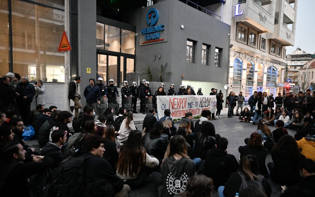 Students hold a tribute outside the Hellenic Train headquarters, in Athens on 1 March, to the victims of a deadly train crash. Hundreds took to the streets in Athens, blaming the government for the privatisation of the Hellenic Train company.