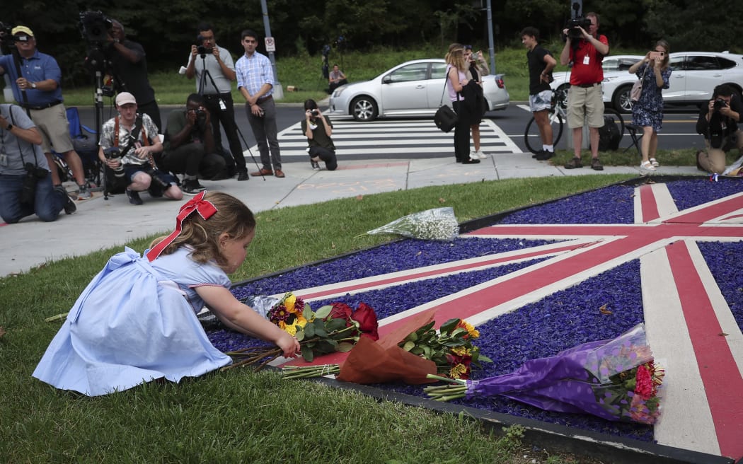 India Rodgers, 3, lays flowers outside the British Embassy after the death of Queen Elizabeth II was announced on September 9, 2022 in Washington, DC.