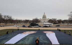 A photo of President Donald Trump and convicted sex offender Jeffrey Epstein is unfurled on the National Mall near the U.S. Capitol by the political protest organizations Everyone Hates Elon and Glasgow Actions Team on December 15, 2025 in Washington, DC. The U.S. Department of Justice is required by the Epstein Files Transparency Act to release files related to Epstein on December 19.   Heather Diehl/Getty Images/AFP (Photo by Heather Diehl / GETTY IMAGES NORTH AMERICA / Getty Images via AFP)