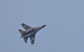 A Chinese military jet flies over Pingtan island, one of mainland China's closest points to Taiwan, on 6 August, 2022.