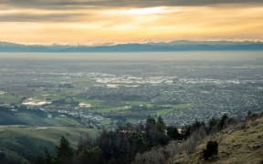 Panoramic sunset shot of city with mountains backdrop,shot in Port Hills location above Christchurch, South Island of New Zealand