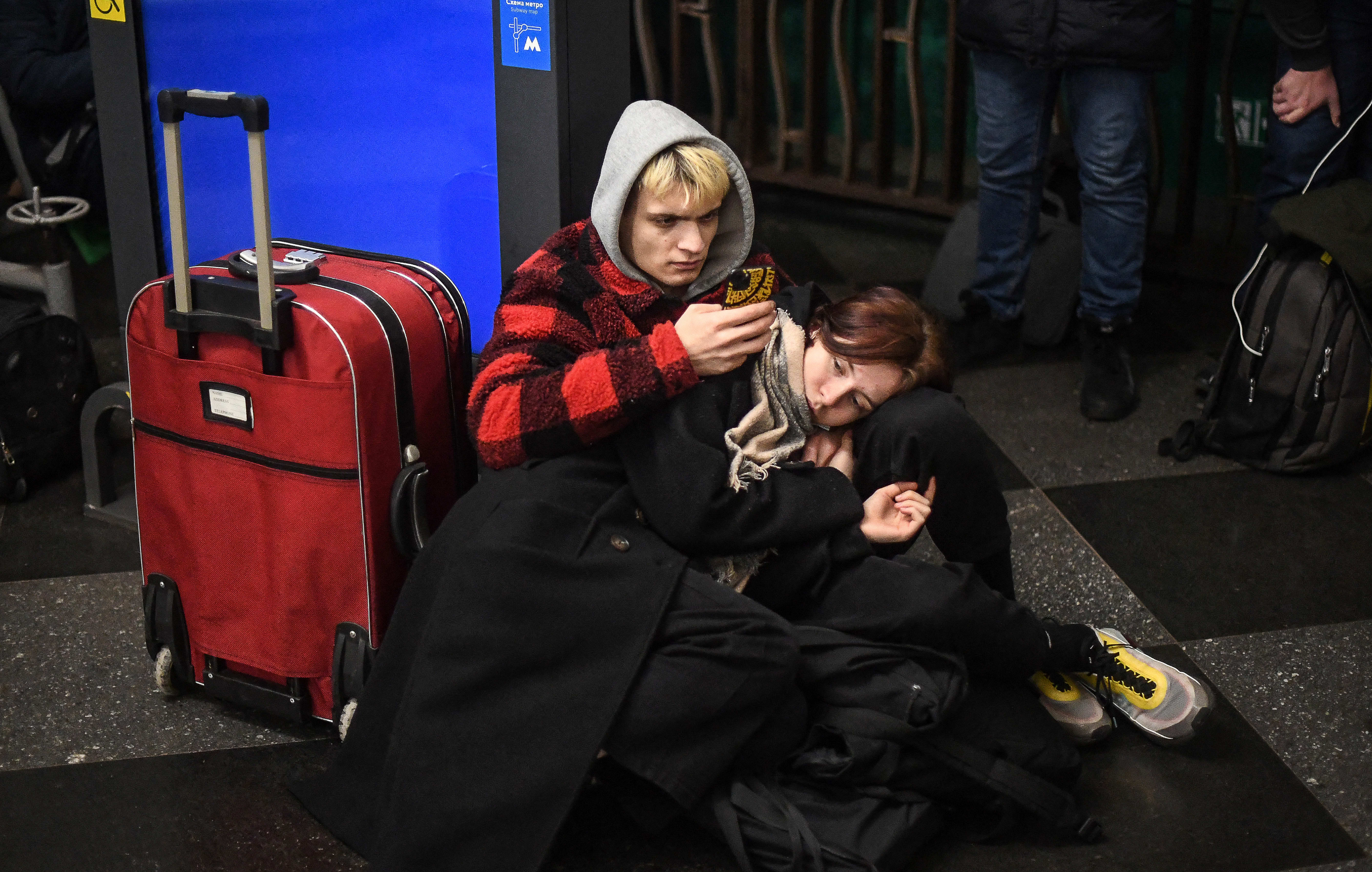 People use their phone as they take shelter in a metro station in Kyiv as air raid sirens rang out.