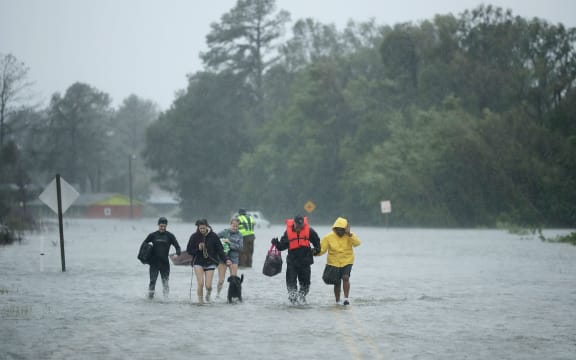 Volunteers from the Civilian Crisis Response Team help people to higher ground after rescuing them from their flooded homes during Hurricane Florence in James City, North Carolina.
