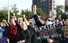 Protesters raise their fists to show solidarity at the Black Lives Matter march in Auckland on 14 June, 2020.