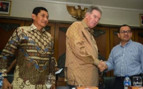 Freeport-McMoRan Chairman James R. Moffett, shakes hands with Indonesia's Minister of Energy and Mineral Resources Sudirman Said. To the left is President Director of Freeport Indonesia, Maroef Sjamsoeddin.