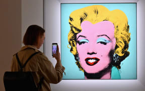 A woman takes a photo of Andy Warhol's 'Shot Sage Blue Marilyn' during Christie's 20th and 21st Century Art press preview at Christie's New York on April 29, 2022 in New York City.