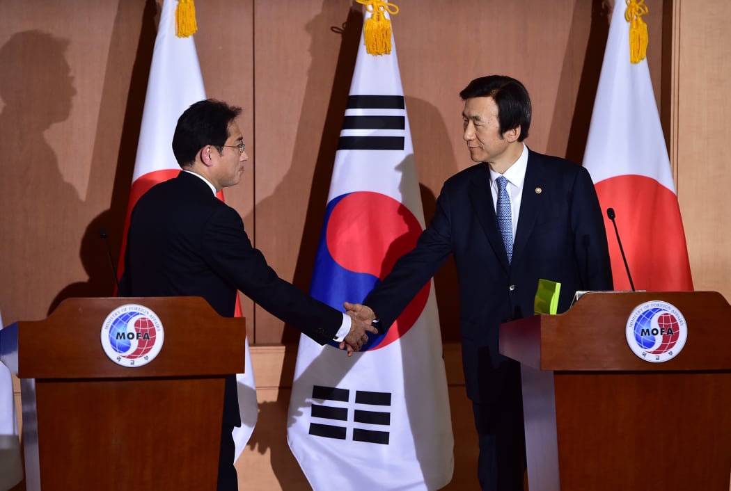 Japan's Foreign Minister Fumio Kishida (L) shakes hands with his South Korean counterpart Yun Byung-Se (R) after a joint press briefing at the Foreign Ministry in Seoul on December 28, 2015.