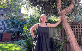 Piera Maclean leaning on a feijoa tree.