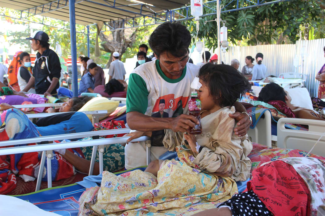 Injured victims rest at a makeshift hospital in Pemenang, the day after a 6.9 magnitude earthquake struck the area.