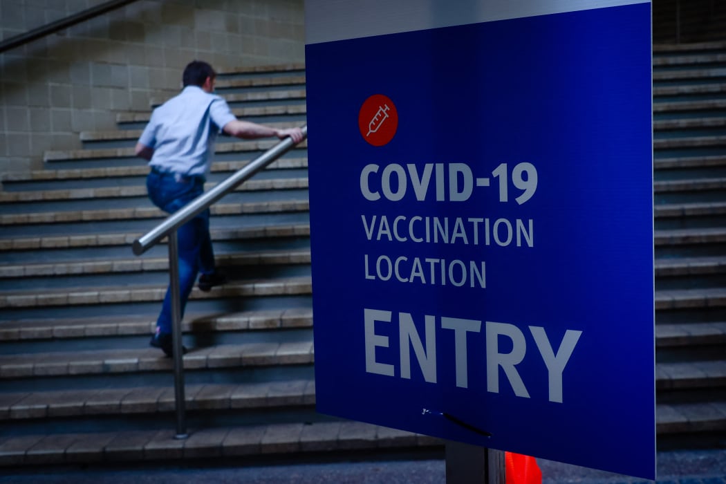 A man walks past signage at a Covid-19 vaccination hub at the Brisbane Convention and Exhibition Centre.