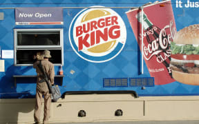 A US soldier passes an order at a Burger King shop in Bagram air base on 4 October 2004.