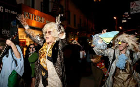 A still from the documentary Sabbath Queen. A street march featuring performers dancing and singing.