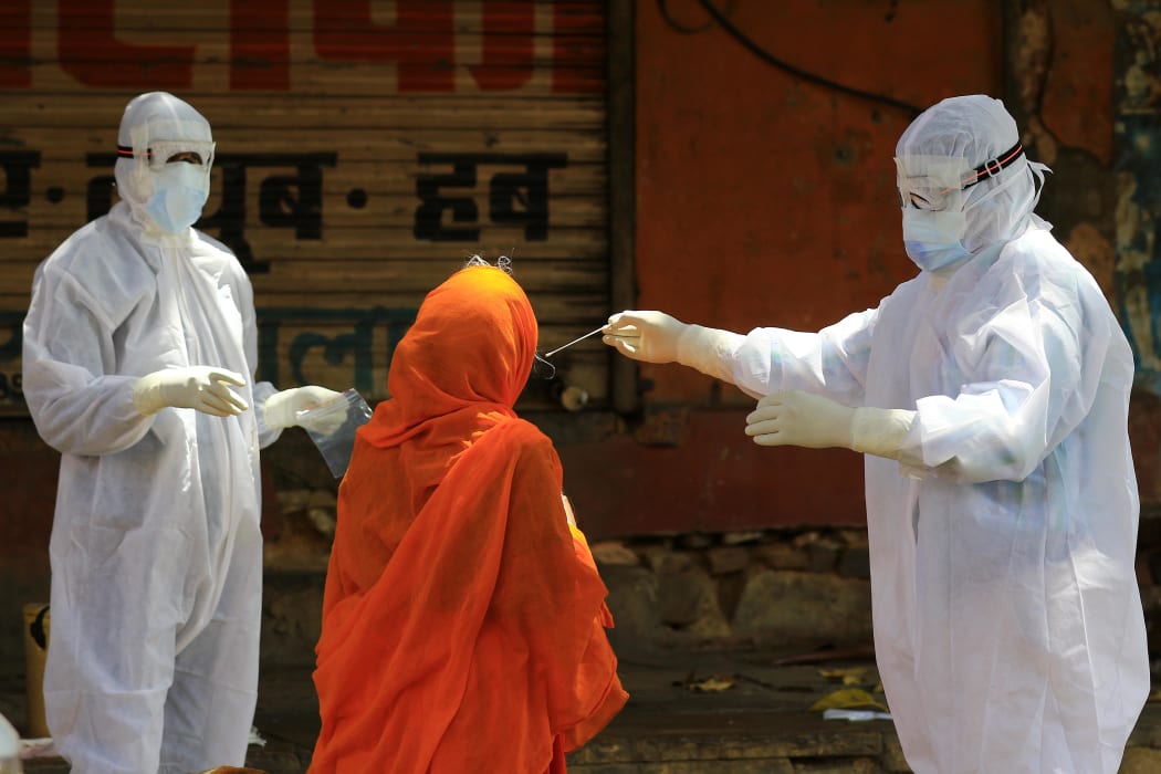 A medic collects a swap sample of an elderly woman during a door-to-door examination of COVID-19 in Jaipur, Rajasthan, India on April 15, 2020.