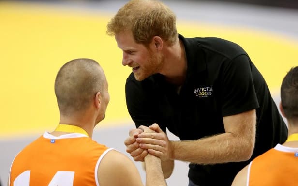 Prince Harry awards the silver medal to Walter Groen of the Netherlands on the podium at the medal ceremony for the Wheelchair Basketball final gold match.