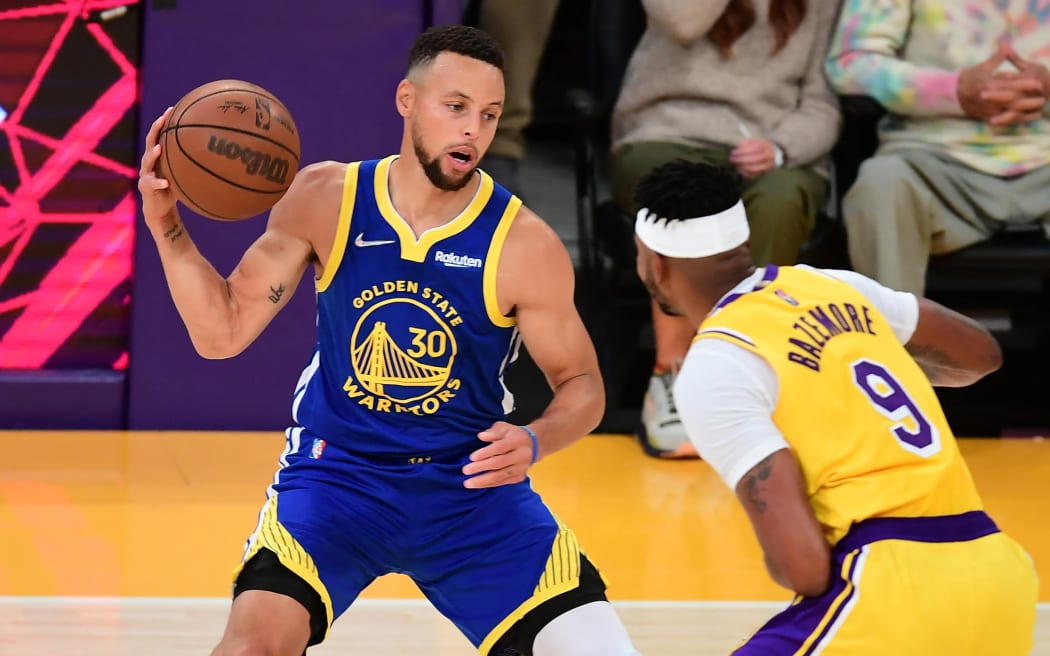 Stephen Curry of the Golden State Warriors (left) tries to get past Kent Bazemore of the Los Angeles Lakers during their NBA season opener on Tuesday.