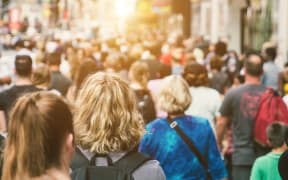 Unrecognisable mass of people walking in a city