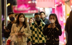 Masked people walk on Sai Yeung Choi South street, in Hong Kong, China, on February 5, 2022, in Hong Kong, China, on February 5, 2022. (Photo by Marc Fernandes/NurPhoto) (Photo by Marc Fernandes / NurPhoto / NurPhoto via AFP)
