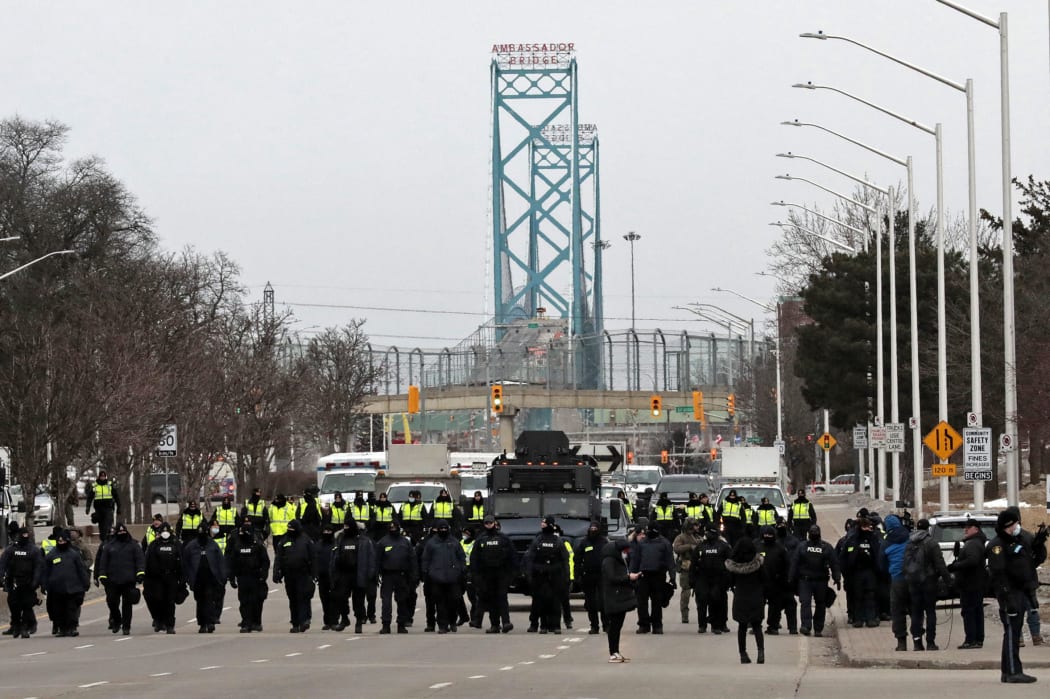 Police gather to clear protestors against Covid-19 vaccine mandates who blocked the entrance to the Ambassador Bridge in Windsor, Ontario, Canada, on 13 February 2022.