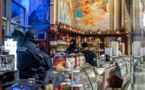 05 December 2018, North Rhine-Westphalia, Duisburg: Policemen are standing in an ice cream parlour in the Citypalais in downtown Duisburg. Investigators in Germany, Italy, the Netherlands and Belgium have raided members of the Italian mafia organisation 'Ndrangheta.
