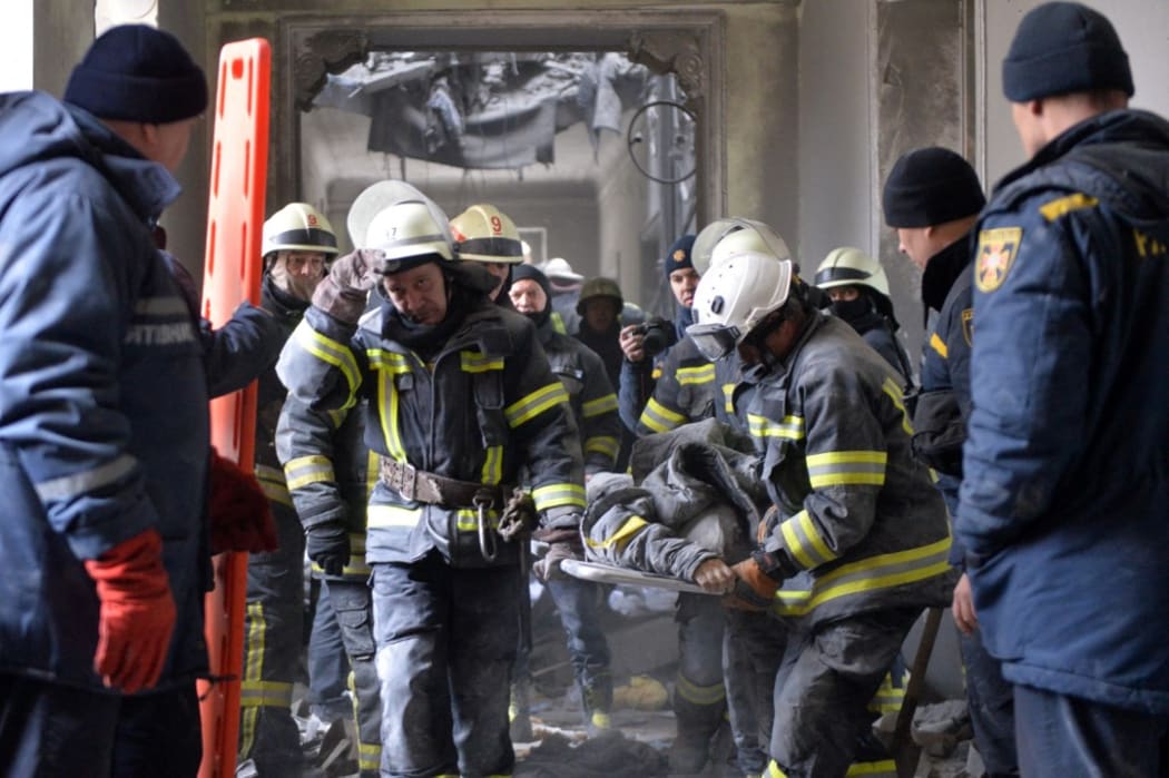 Emergency services personnel carry a body out of the damaged local city hall in Kharkiv, Ukraine on 1 March, 2022, after it was shelled by Russian troops.