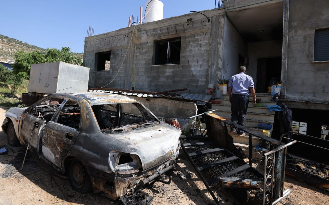 A Palestinian inspects the damage to a home in the village of Mughayir near Ramallah in the Israeli-occupied West Bank on April 13, 2024, after an attack by Israeli settlers on the village. (Photo by JAAFAR ASHTIYEH / AFP)