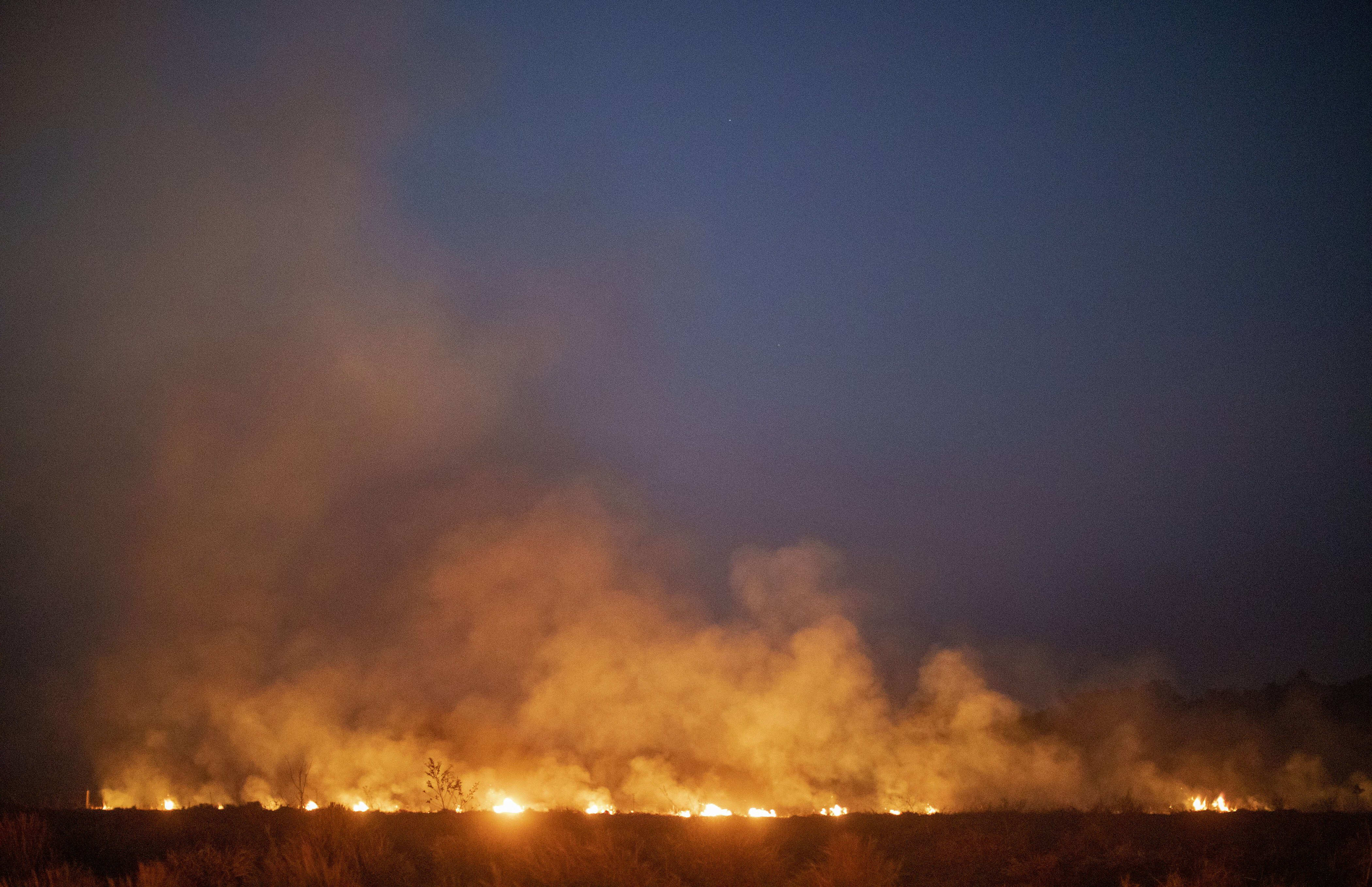 A fire burns out of control after spreading onto a farm along a highway in Nova Santa Helena municipality in northern Mato Grosso State, south in the Amazon basin in Brazil, on August 23, 2019.