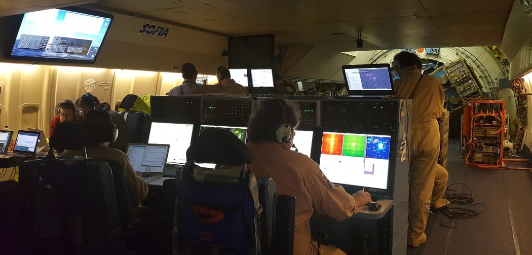 Interior of SOFIA flight 422, with scientists and technicians observing data coming in from the telescope.