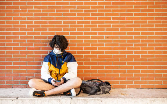 Perpignan, June 10, 2020, Classes resume at the Lycée Arago in Perpignan. History class with wearing of the mask for the teacher and the students. High school student waiting between two classes on his mobile phone and wearing the mask.